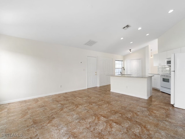 interior space with white appliances, white cabinets, sink, vaulted ceiling, and an island with sink