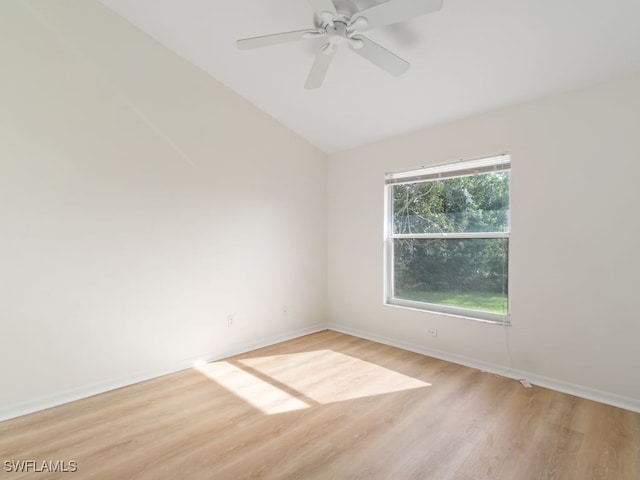 spare room featuring ceiling fan, vaulted ceiling, and light wood-type flooring