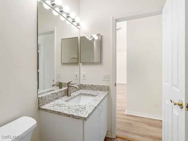 bathroom featuring hardwood / wood-style flooring, vanity, and toilet