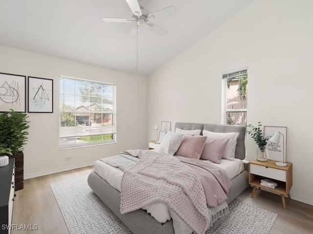 bedroom featuring ceiling fan, light hardwood / wood-style floors, and lofted ceiling