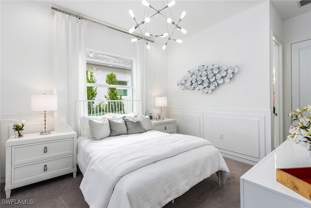 bedroom with an inviting chandelier and dark colored carpet