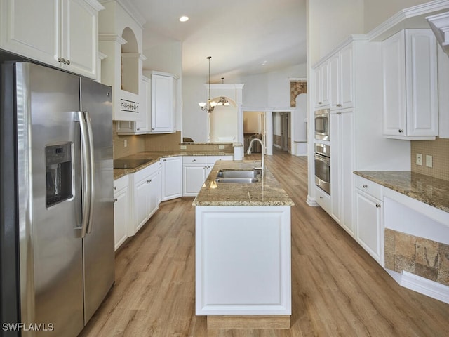 kitchen with white cabinets, appliances with stainless steel finishes, pendant lighting, and a sink