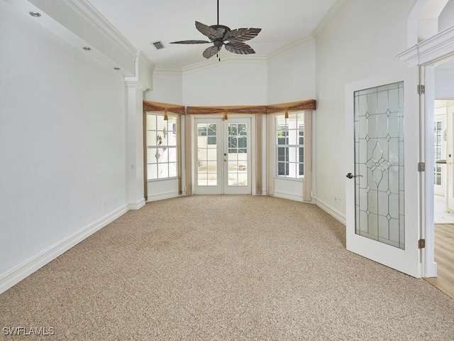 empty room with baseboards, french doors, light colored carpet, and crown molding