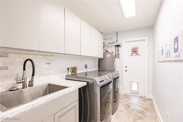 washroom with water heater, sink, washing machine and clothes dryer, and cabinets