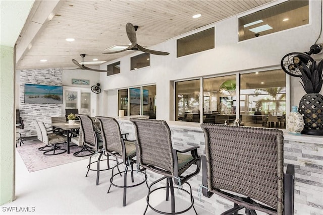 view of patio with ceiling fan and an outdoor bar