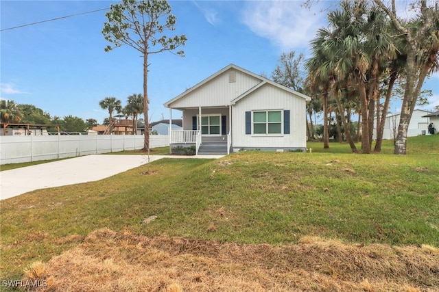 view of front facade featuring fence, a porch, and a front yard