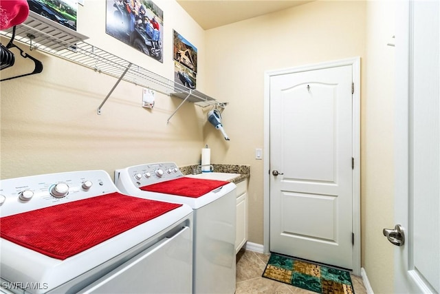 laundry area featuring cabinets, light tile patterned floors, sink, and washing machine and clothes dryer