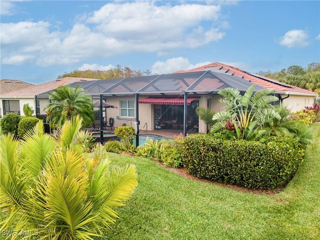 rear view of property featuring glass enclosure and a lawn