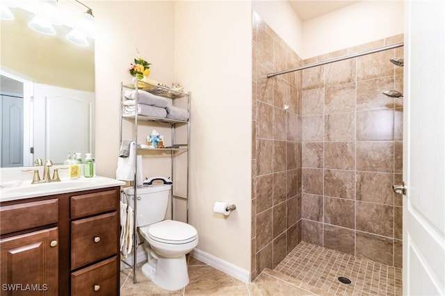 bathroom with a tile shower, tile patterned floors, vanity, and toilet