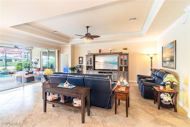 tiled living room with a raised ceiling, ceiling fan, and crown molding