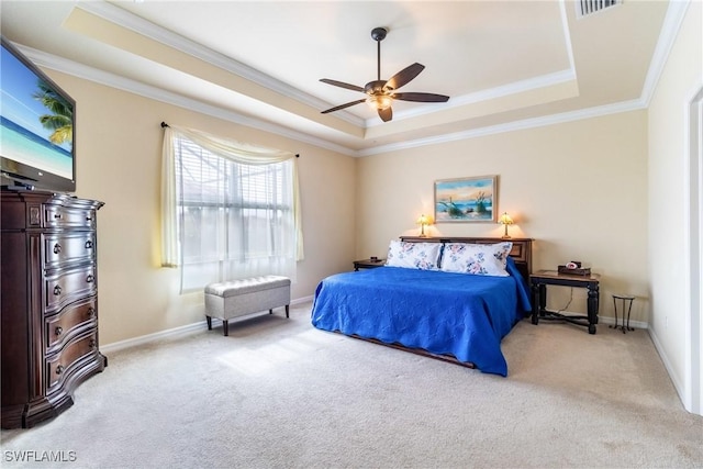 carpeted bedroom with a tray ceiling, ceiling fan, and ornamental molding