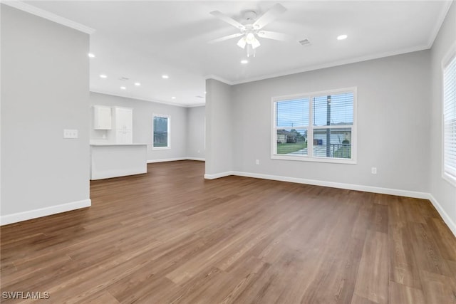837 Da Vinci Ave S, Lehigh Acres, FL 33974 - unfurnished living room with visible vents, crown molding, baseboards, and wood finished floors