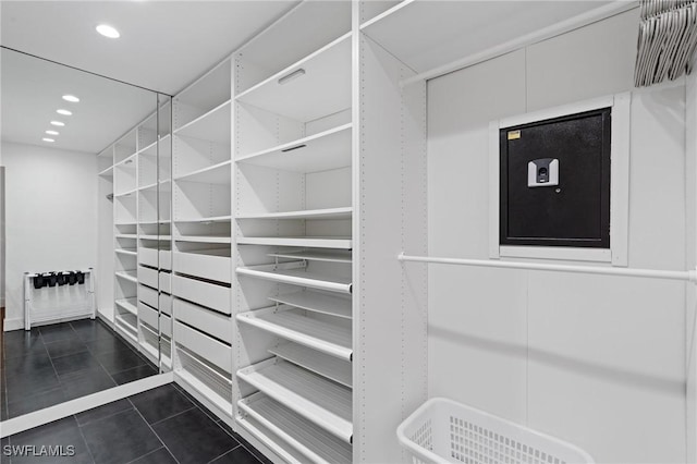 spacious closet with dark tile patterned floors