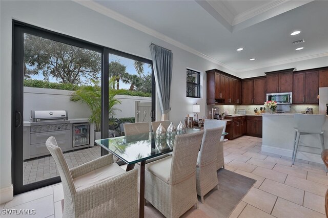 dining room featuring wine cooler, crown molding, and light tile patterned flooring