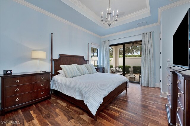 bedroom featuring dark hardwood / wood-style floors, access to outside, crown molding, an inviting chandelier, and a tray ceiling