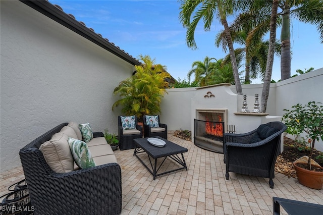 view of patio featuring an outdoor living space with a fireplace