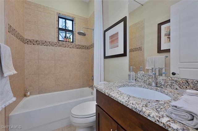 full bathroom featuring toilet, tiled shower / bath, and vanity