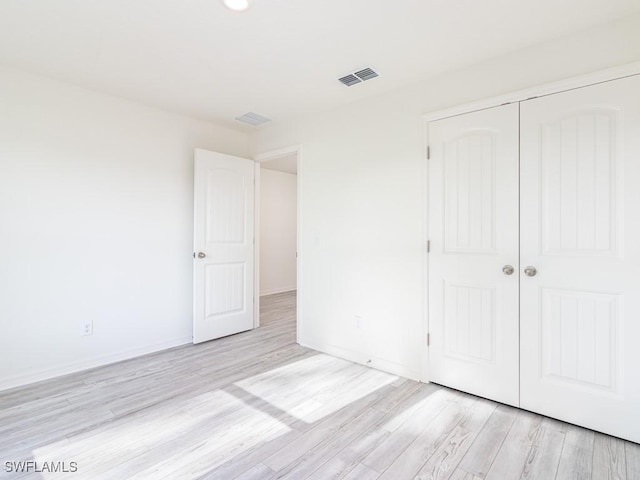 unfurnished bedroom featuring light wood-type flooring and a closet