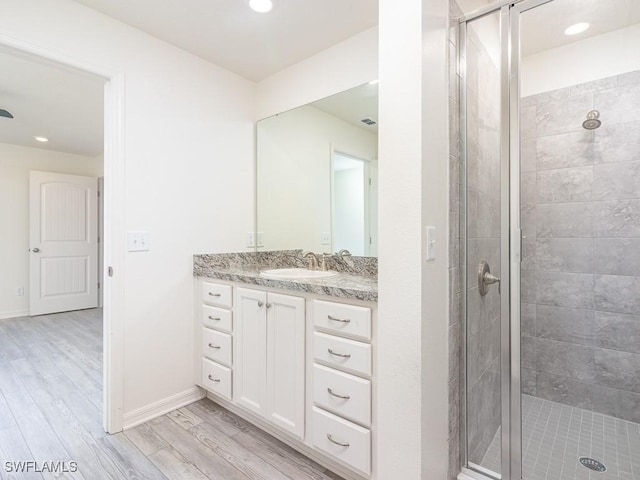 bathroom with vanity, hardwood / wood-style floors, and a shower with shower door