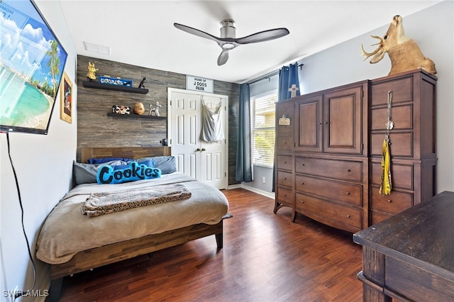 living area featuring ceiling fan, dark wood-type flooring, and wood walls