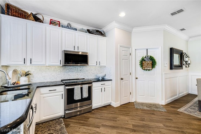 kitchen featuring sink, crown molding, white cabinetry, dark wood-type flooring, and appliances with stainless steel finishes