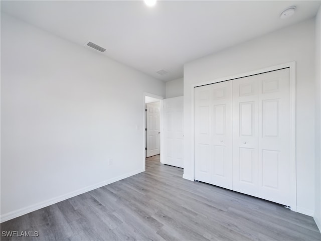 unfurnished bedroom with a closet and wood-type flooring