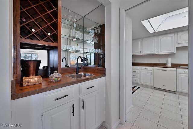 bar featuring white cabinets, sink, dishwasher, butcher block countertops, and light tile patterned flooring