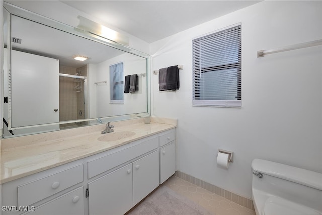 bathroom featuring tile patterned floors, walk in shower, vanity, and toilet