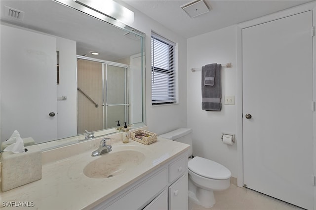 bathroom with tile patterned flooring, vanity, toilet, and a shower with shower door