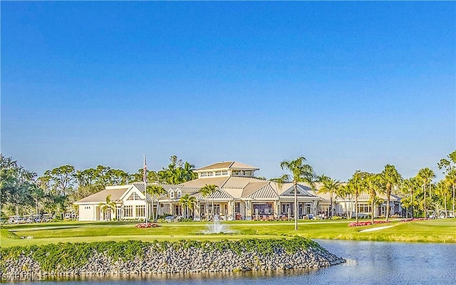 view of front facade with a water view and a front lawn