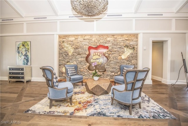 living area with dark hardwood / wood-style floors and coffered ceiling