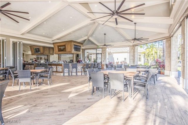 dining room with lofted ceiling with beams and light hardwood / wood-style floors