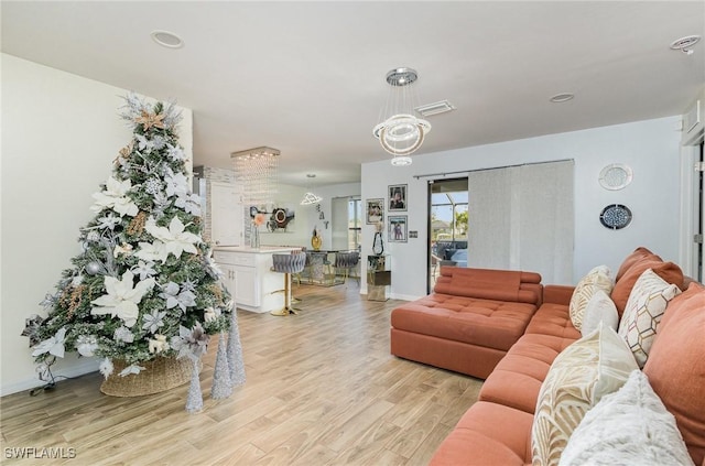 living room featuring light hardwood / wood-style floors and an inviting chandelier