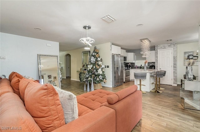 living room featuring a chandelier and light hardwood / wood-style floors