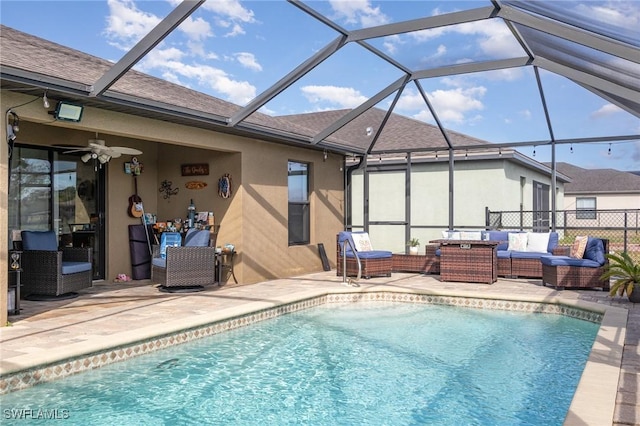 view of swimming pool featuring a patio area, ceiling fan, glass enclosure, and an outdoor hangout area