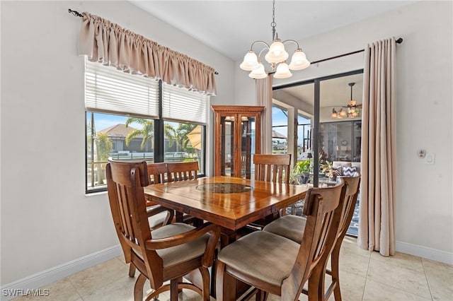 dining space featuring light tile patterned floors and a notable chandelier