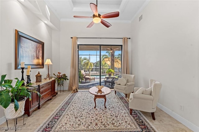 living area with a tray ceiling, crown molding, and ceiling fan