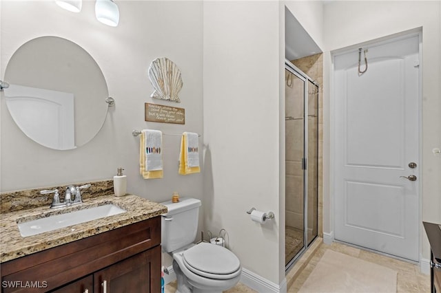 bathroom with a shower with door, vanity, tile patterned floors, and toilet