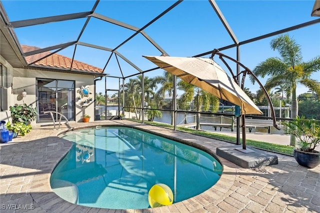 view of pool with a lanai, a patio area, and a water view