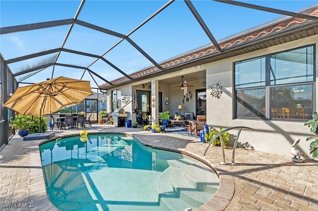 view of swimming pool featuring ceiling fan, a lanai, and a patio