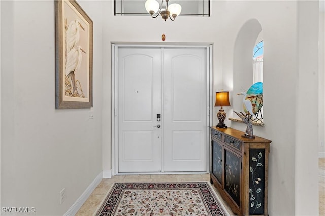 tiled entrance foyer featuring a notable chandelier