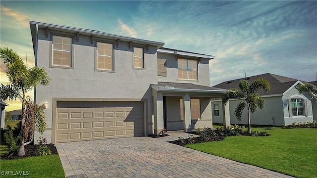 view of front of home featuring a lawn and a garage