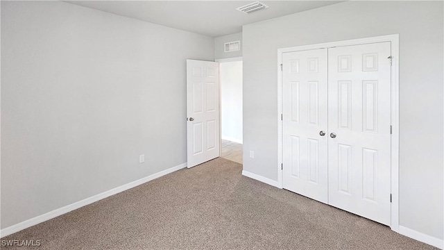 unfurnished bedroom featuring carpet and a closet