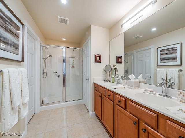 bathroom with tile patterned flooring, vanity, and walk in shower