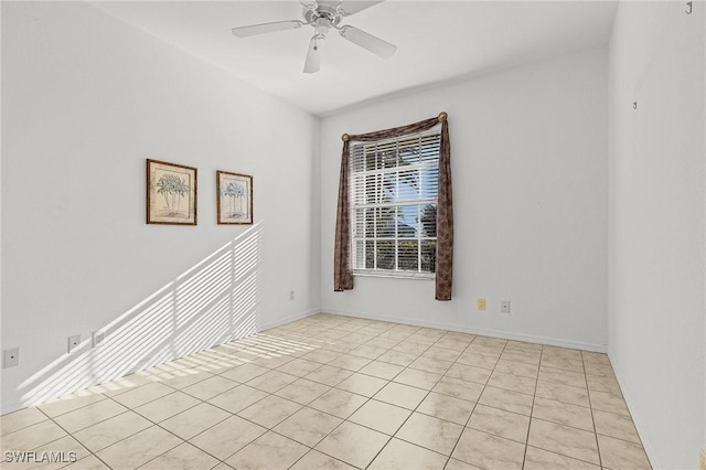 empty room with ceiling fan and light tile patterned floors