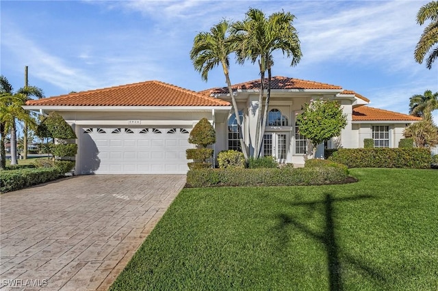 mediterranean / spanish-style house with a garage and a front lawn