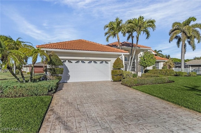 mediterranean / spanish-style house with a garage and a front lawn