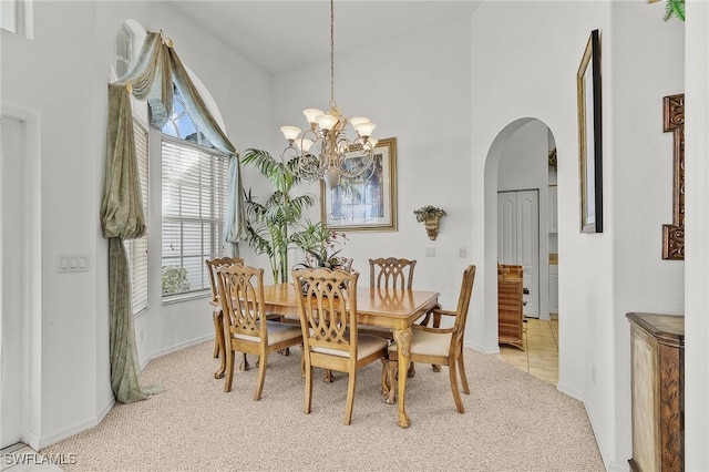 carpeted dining area featuring a notable chandelier