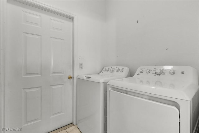 laundry room with light tile patterned flooring and washer and dryer