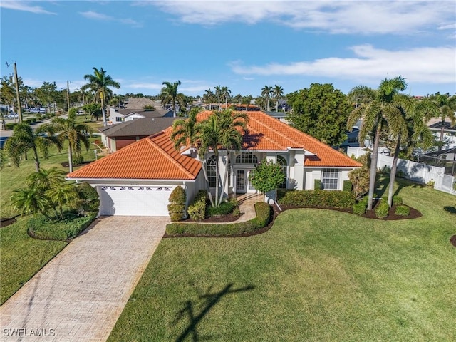 mediterranean / spanish house with a garage and a front yard